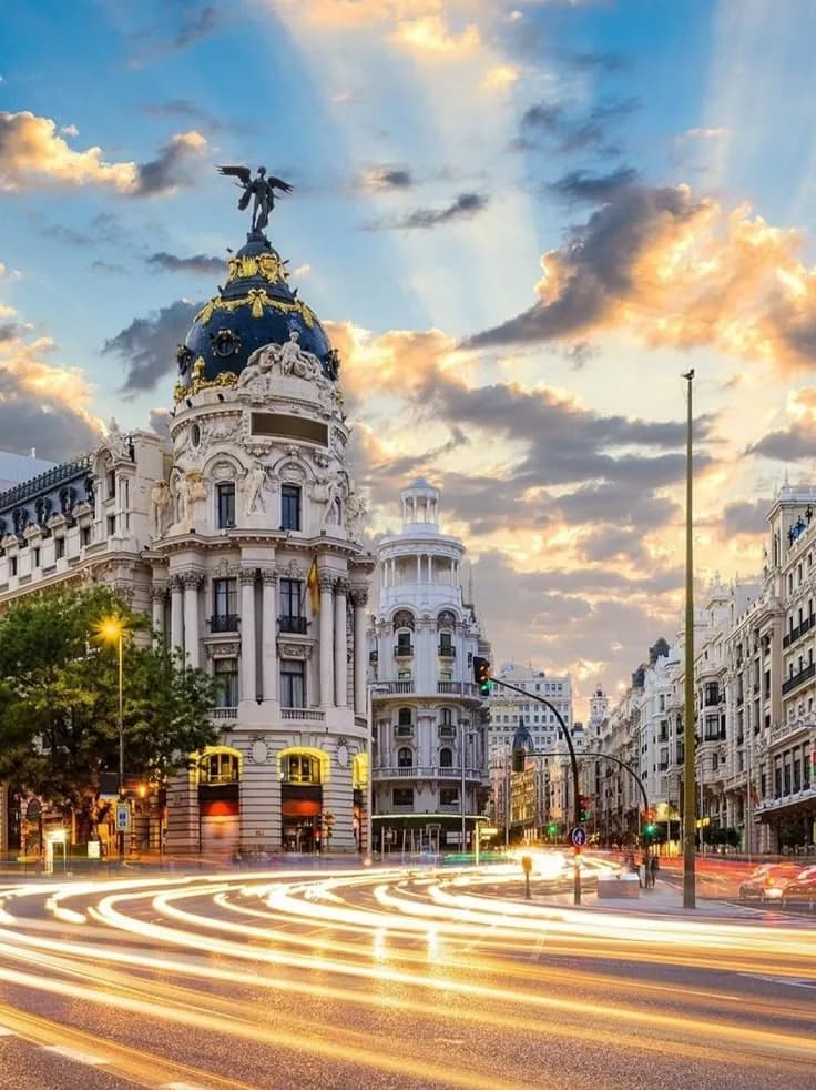 Edificio Metrópolis en la Gran Vía de Madrid al atardecer, con estelas de luz del tráfico