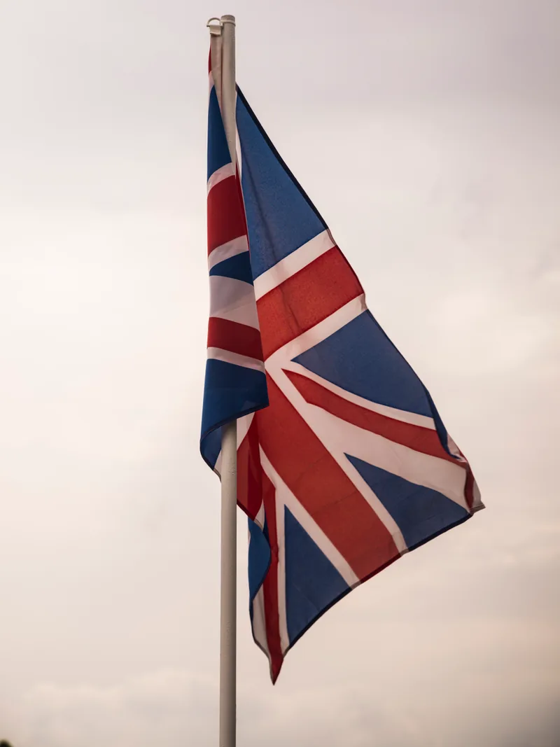 Bandera del Reino Unido ondeando en un mástil contra un cielo nublado